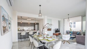 A modern open-plan living space with a dining area, kitchen, and seating area. - Villa Prol26, Stunning 3bdr Protaras Villa with Pool, Close to Fig Tree Bay (Protaras)