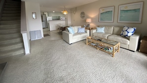 A living room with a sofa, coffee table, and a staircase. - South Haven Condo w/ LAKE MICHIGAN + LIGHTHOUSE VIEWS w/ POOL + PRIVATE BEACH  (South Haven)