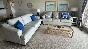 A living room with two sofas, a coffee table, and wall art. - South Haven Condo w/ LAKE MICHIGAN + LIGHTHOUSE VIEWS w/ POOL + PRIVATE BEACH  (South Haven)