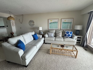 Ein Wohnzimmer mit zwei Sofas, einem Couchtisch und Wandbildern.