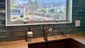 A kitchen with a window, a faucet, and a soap dispenser. - Modern Treat: Stunning Remodeled Townhome (Palm Springs)