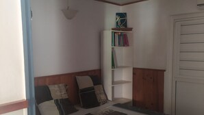 A bedroom with a bed, a bookshelf, and a wardrobe.