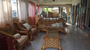 A spacious living area with a sofa set, a coffee table, and a dining table with chairs.