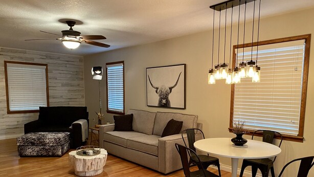 A living room with a ceiling fan, a sofa, a coffee table, and a dining table with chairs. - Eastside Modern Farmhouse in downtown Kalispell (Kalispell)
