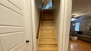 A wooden staircase leading to a living area with a sofa and a lamp. - Eastside Modern Farmhouse in downtown Kalispell (Kalispell)