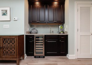 A kitchen with dark wood cabinets, a glass backsplash, and a built-in oven.