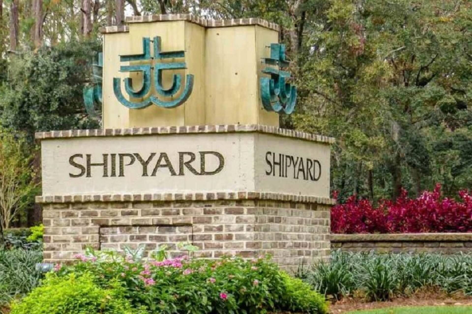 Un letrero con la palabra 'SHIPYARD' en letras grandes, rodeado de follaje y árboles.