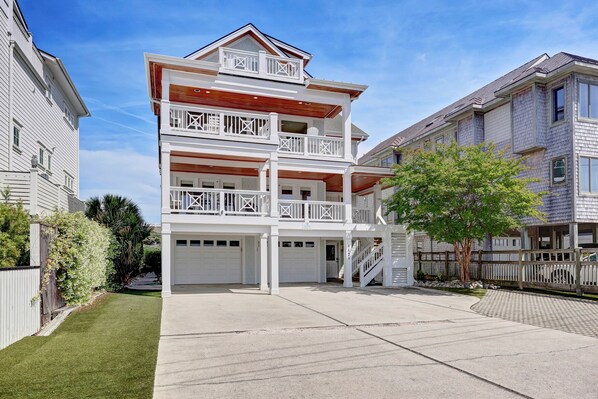 A multi-story residential building with a central staircase, balconies, and a garage.