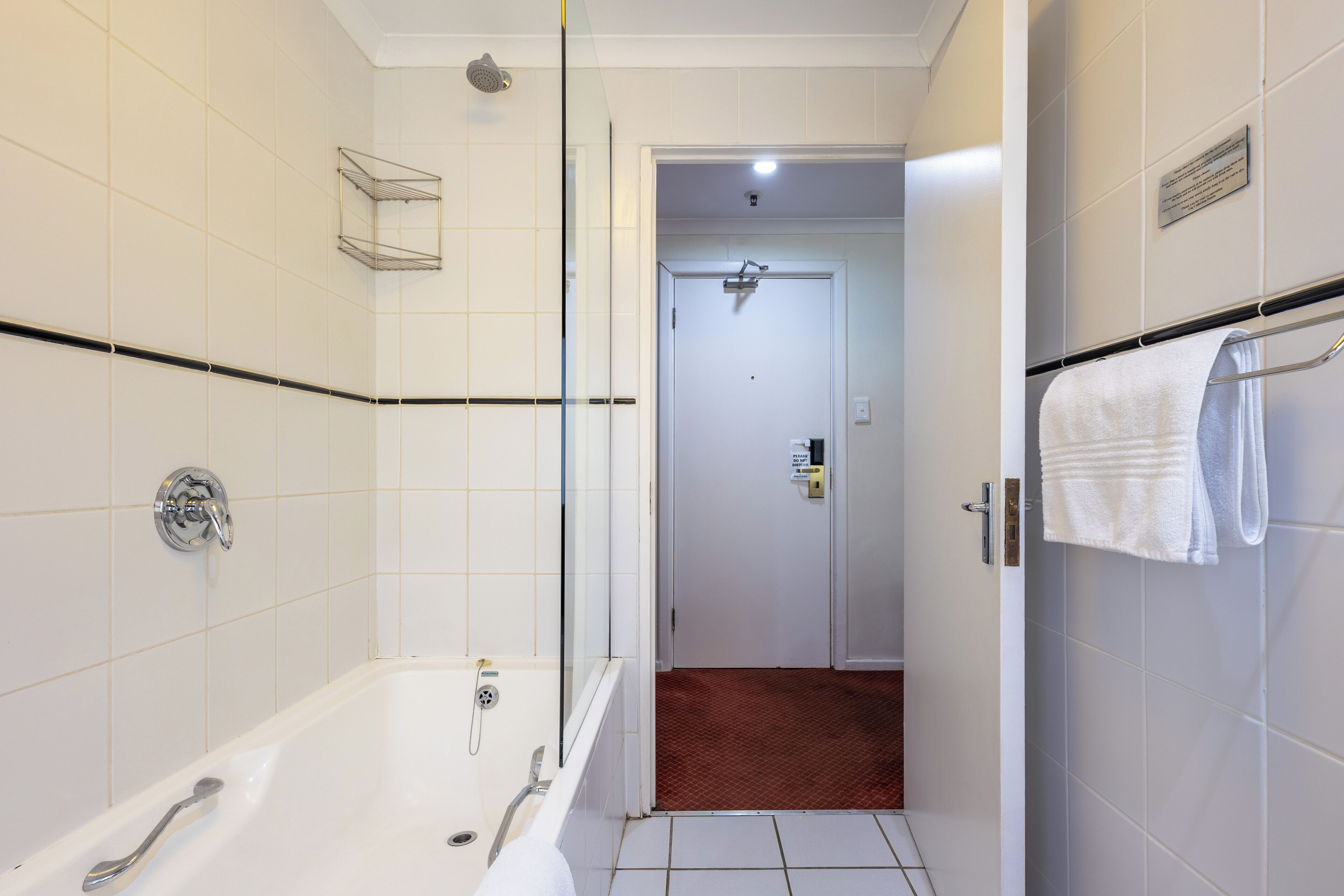 A modern bathroom with a bathtub, shower, and a towel rack.