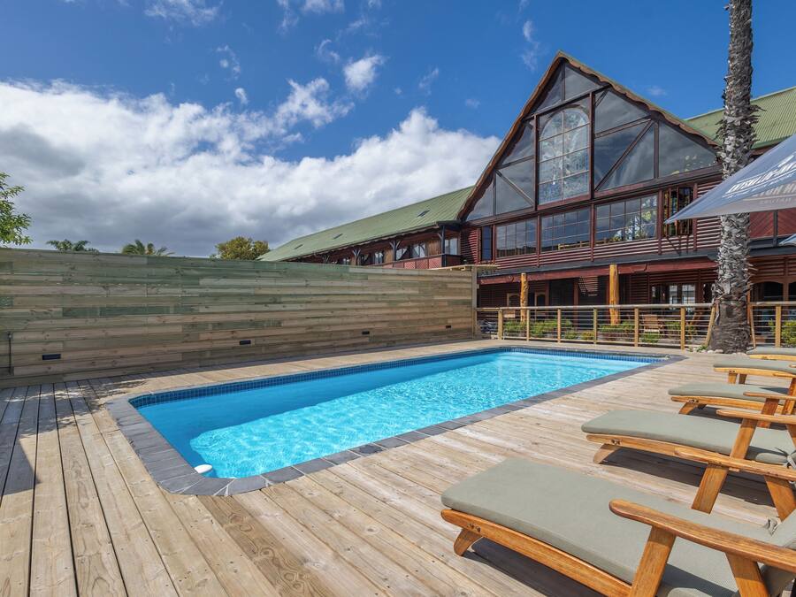 Una piscina al aire libre, sombrillas, tumbonas
