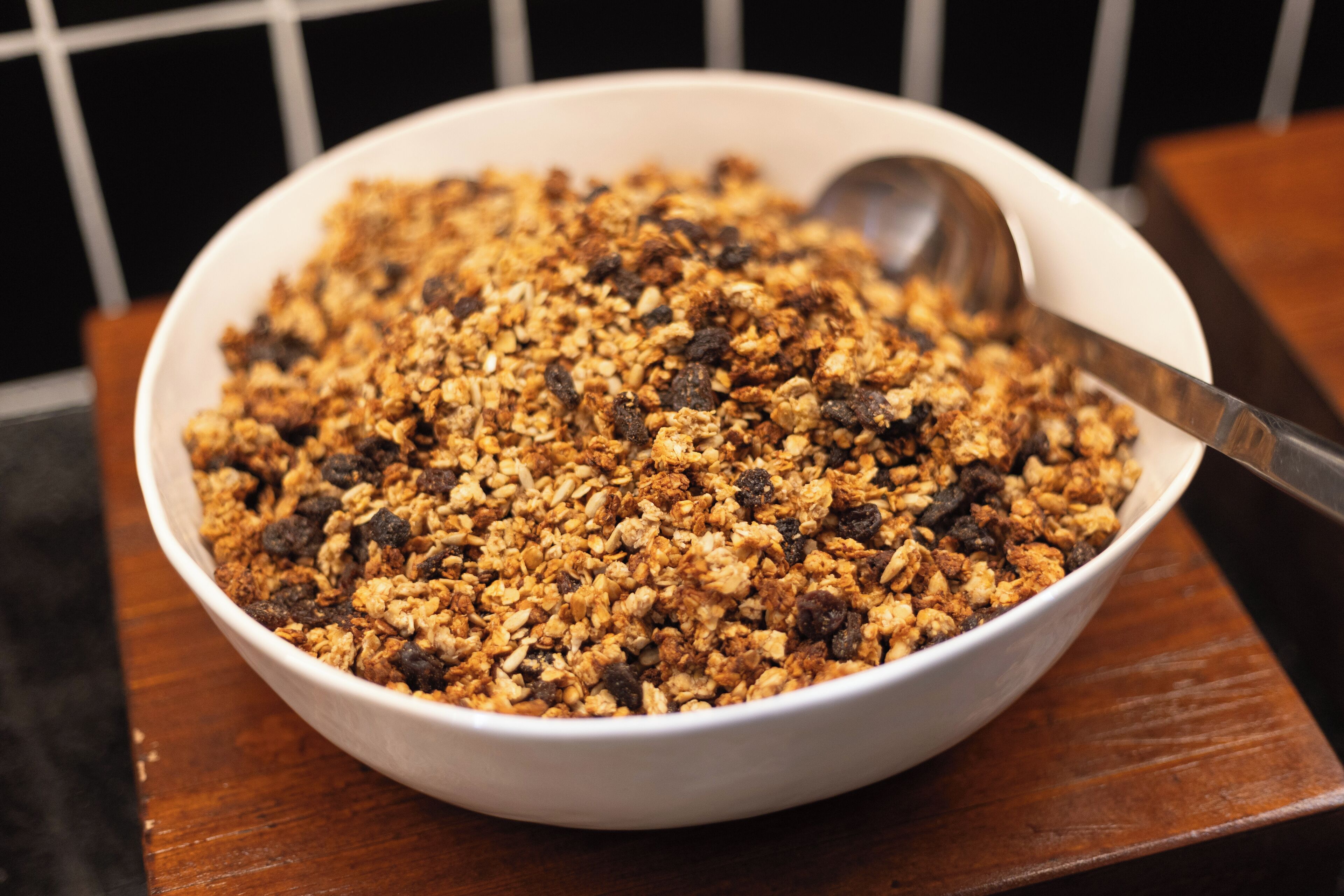 Uma tigela de granola com passas sobre uma mesa de madeira.