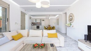 Ein modernes Wohnzimmer mit Sofa, Couchtisch und einem Fernsehmöbel.