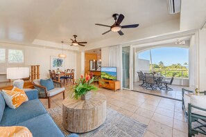 A spacious living room with a sofa, coffee table, and a balcony with a view.