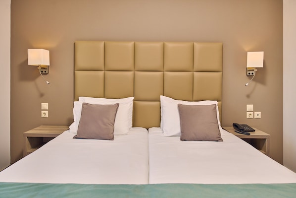 A hotel room with a large bed, two bedside tables, a telephone, and wall-mounted lamps. - Tsilivi Beach Hotel (Zakynthos)