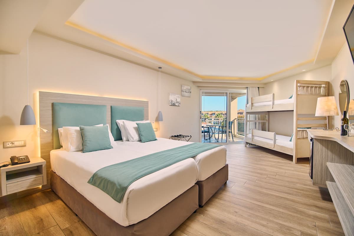 Quarto de hotel moderno com uma cama grande, uma escrivaninha e varanda com vista.