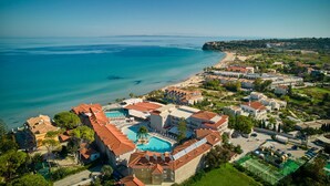 An aerial view of a coastal resort with a swimming pool, beachfront villas, and a clear view of the sea. - Tsilivi Beach Hotel (Zakynthos)
