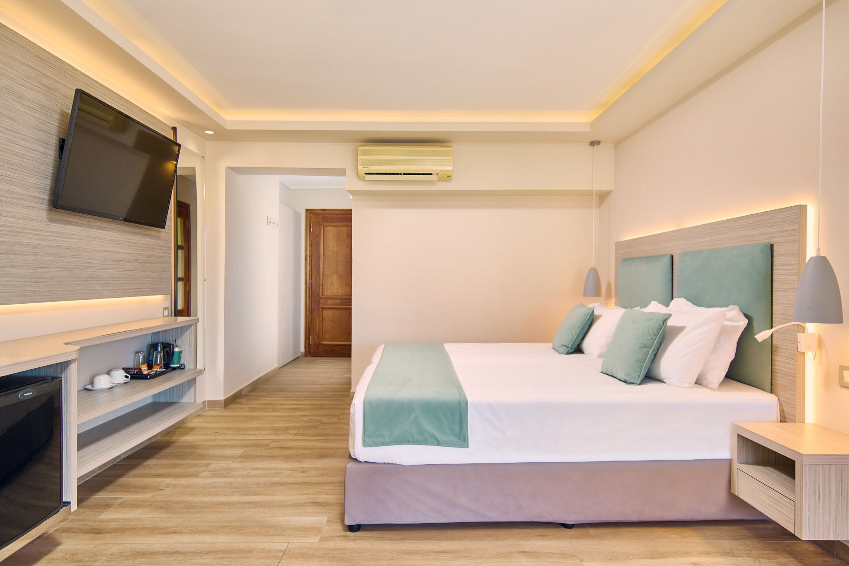 Une chambre d’hôtel moderne équipée d’un lit, d’une télévision et d’un système de divertissement intégré.