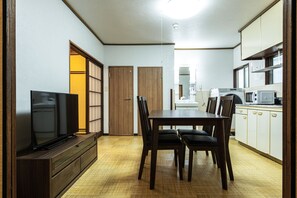 A compact living space with a dining area, kitchen, and a television. - Urban Stay Aoto (Tokyo)