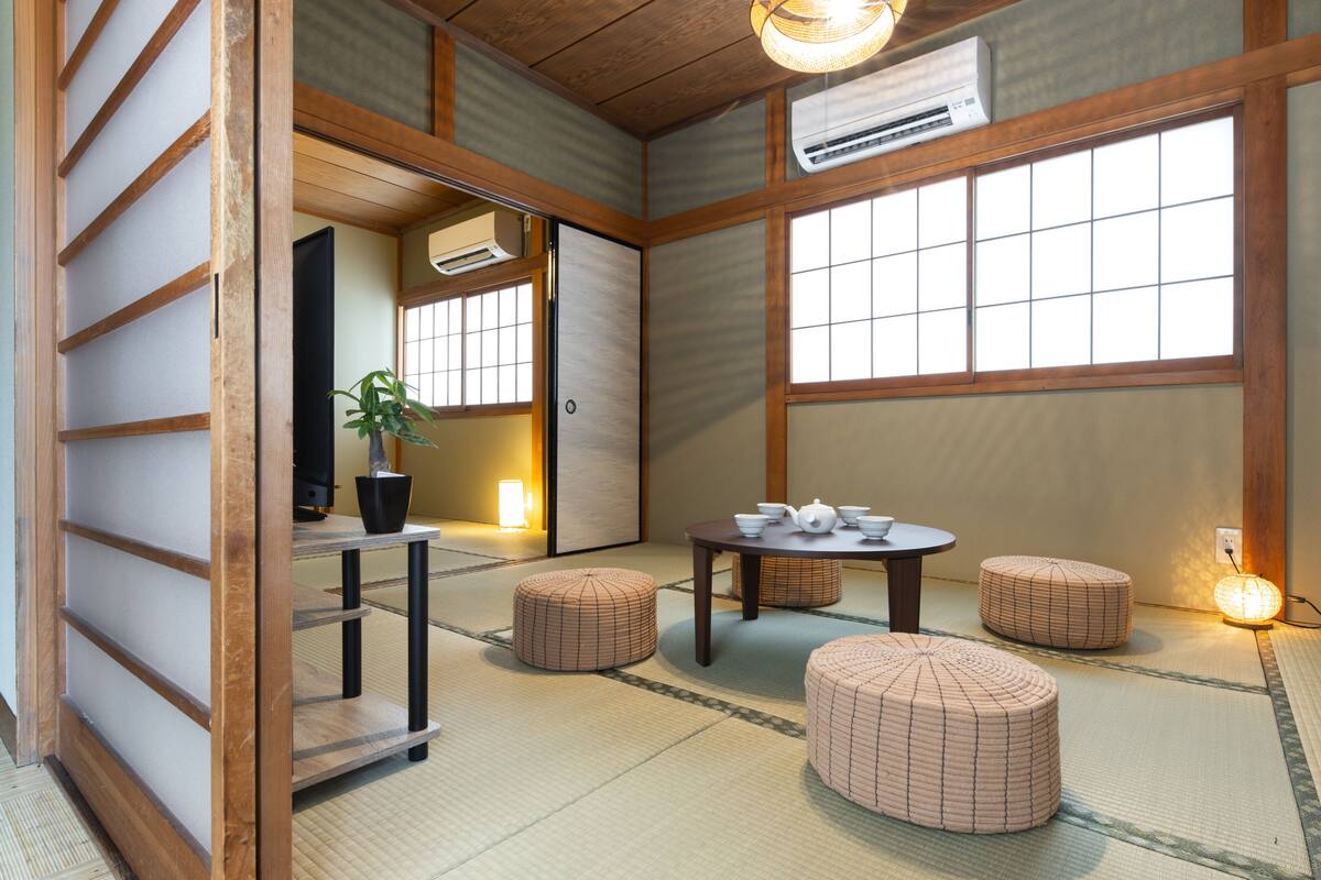 A traditional Japanese room with tatami flooring, a tatami mat table, and a shoji screen door.