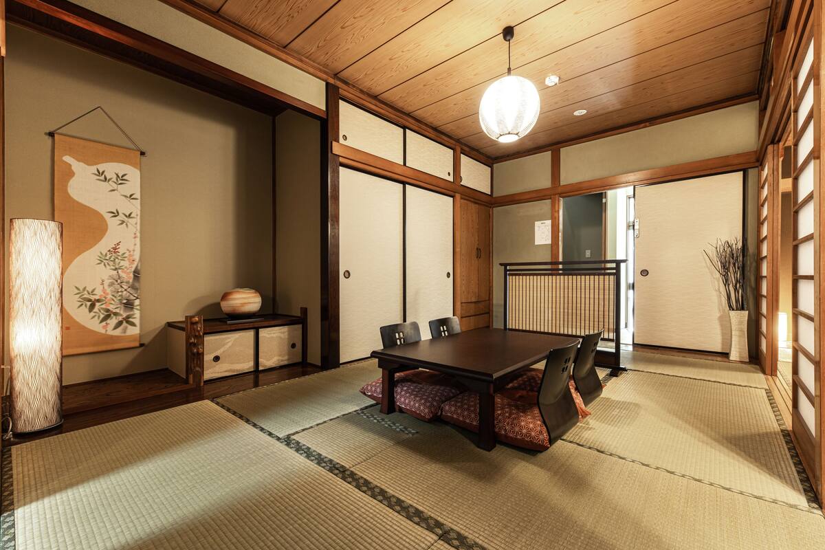 A traditional Japanese room with tatami flooring, a low wooden table, and shoji screens.
