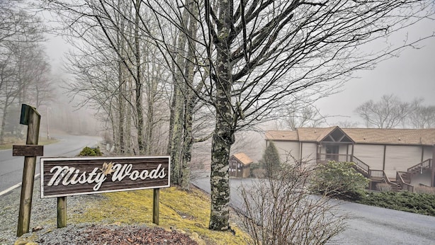 Señalización de 'Misty Woods', con un camino de grava y árboles al fondo.