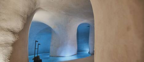 Un interior con un techo alto abovedado y una habitación iluminada con luz azul.