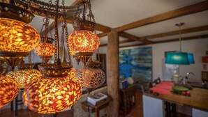 Une cuisine avec des lampes décoratives suspendues, un tableau au mur et une lampe bleue posée sur le comptoir.