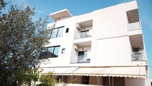 A multi-story building with balconies, large windows, and a flat roof. - Eos ApartHotel (Ksamil)