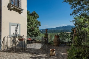 Enjoy a serene view of rolling hills from the balcony of this traditional building.