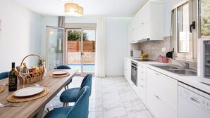Een moderne keuken met witte kasten, een inbouwoven en een groot raam.