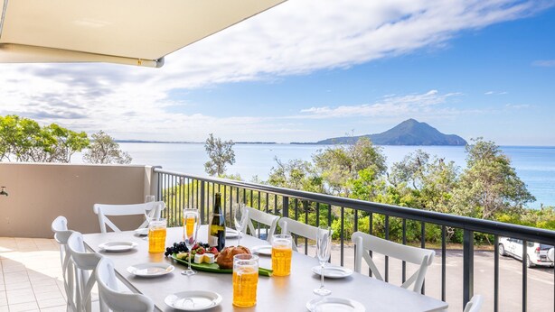 A table set for dining with a view of the sea and a mountain in the background. - Albacore 6, 12-14 Ondine Close (Nelson Bay)