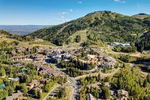 A residential area with houses, roads, and a hilly landscape.