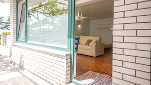 A modern house with a large window, a beige sofa, and a wooden floor. - Apartments Kolenc (Piran)
