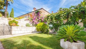 A well-maintained garden with a variety of plants and a stone wall. - Apartments Kolenc (Piran)