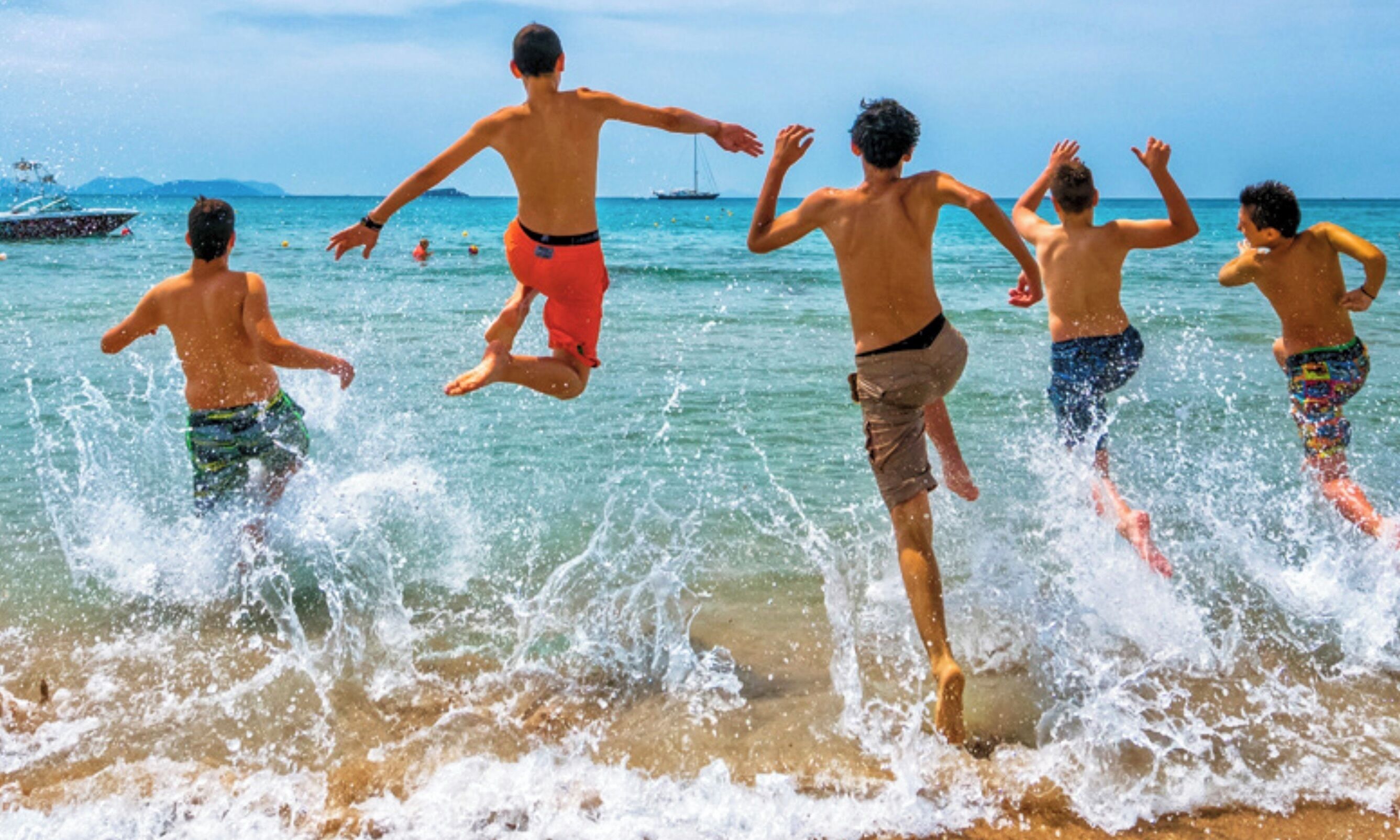 A beach scene with people playing in the water.