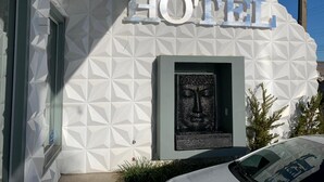 En hotels facade med et geometrisk mønster og et stort 'HOTEL'-skilt over en indrykket indgang.