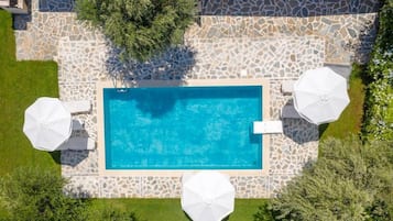Relax by the rectangular pool surrounded by a deck and lush greenery.