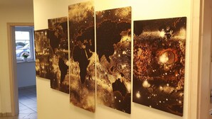 Un couloir orné d’une grande œuvre d’art abstrait au mur, avec un piano et une fenêtre donnant sur l’extérieur.