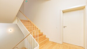 A staircase with wooden steps and white railings leading to a door. - YOUROPO - Flores (Porto)