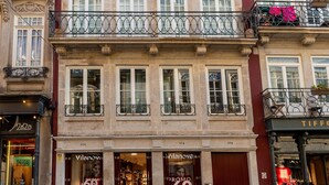 A multi-story building with a ground-floor shop and upper-floor balconies. - YOUROPO - Flores (Porto)