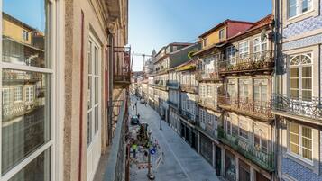 A narrow street lined with historic buildings, some with balconies and terraces.
