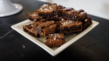 A plate of brownies on a dark surface.