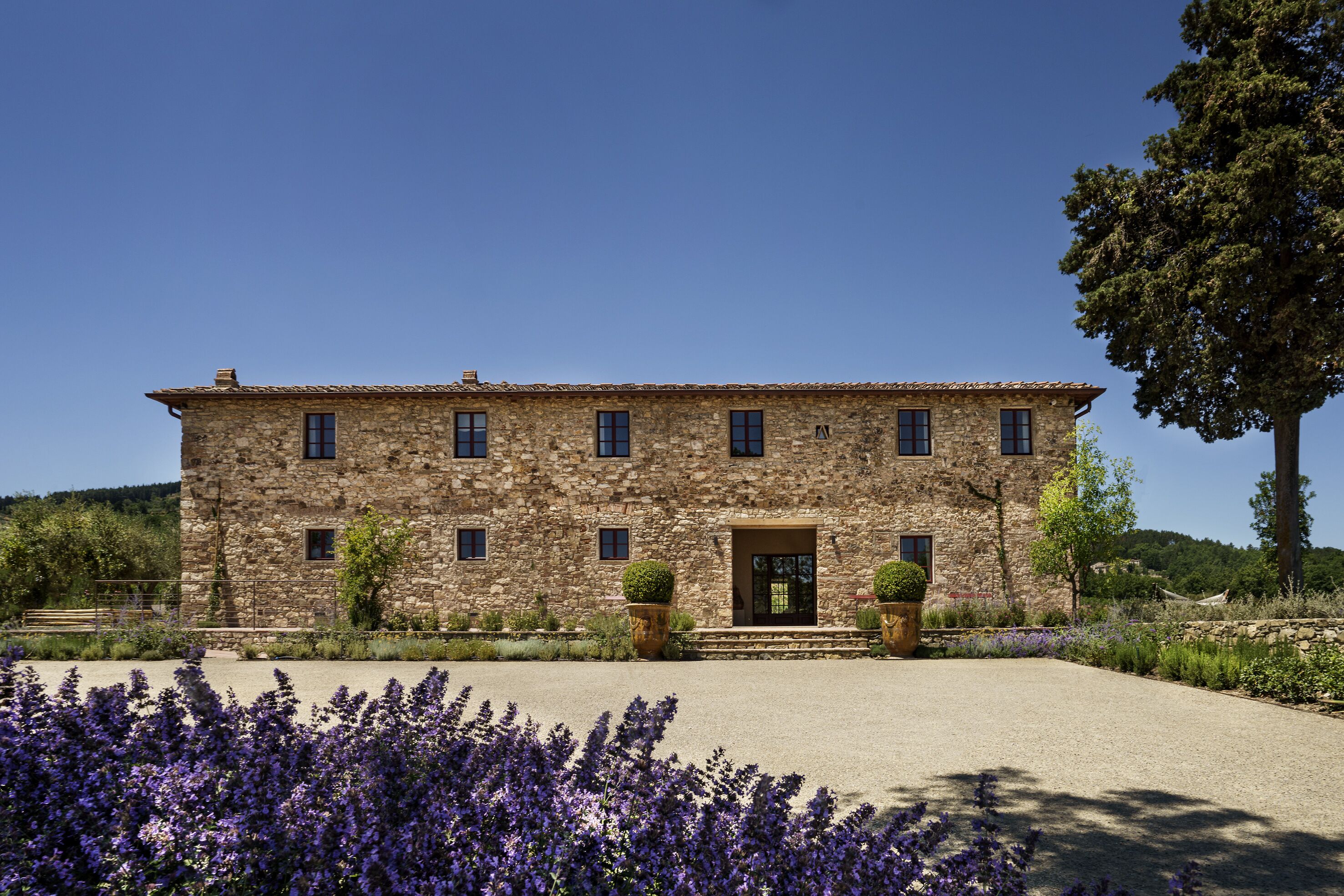 A stone building with a symmetrical facade, multiple windows, and a central entrance.