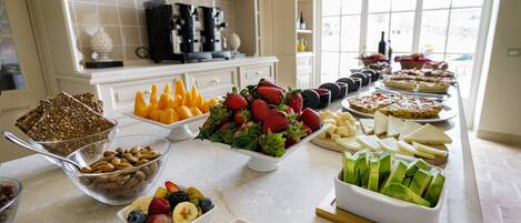 A buffet table with various fruits, vegetables, and breads.