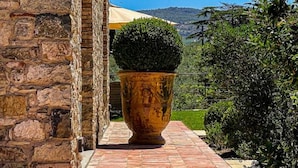 A stone building with a tiled pathway leading to a large planter. - La pietra del cabreo (Greve in Chianti)