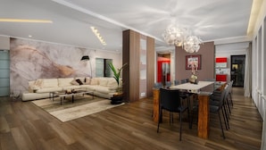 A modern living room with a sectional sofa, a dining area with a glass table, and a kitchen in the background. - Stylish Villa Pedena with a pool and a gym (Sveta Katarina)