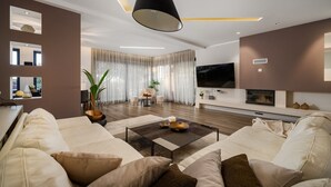 A modern living room with a sofa set, a coffee table, and a TV. - Stylish Villa Pedena with a pool and a gym (Sveta Katarina)