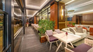 A modern hotel lobby with a long corridor, seating areas, and a large chandelier. - Best Western Premier Hidden Hills (Arnavutköy)