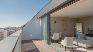 Un appartement moderne doté d’un balcon, d’un canapé, d’une table à manger et de chaises.