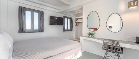 Un dormitorio moderno con cama, escritorio y dos espejos.